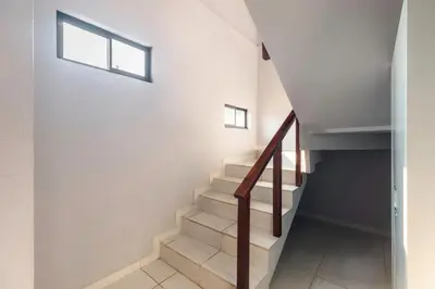 a staircase in a house with two windows at Private home with resort style swimming pool in Jacó