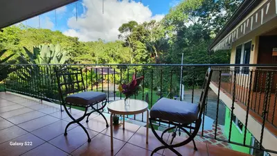 a balcony with two chairs and a table with a view at YETHAN HOUSE in Uvita