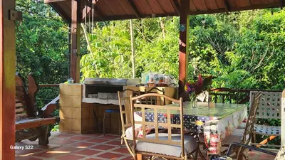 a porch with a table and chairs and trees at YETHAN HOUSE in Uvita