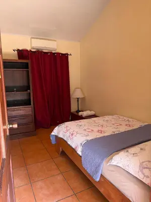 a bedroom with a bed and a red curtain at YETHAN HOUSE in Uvita