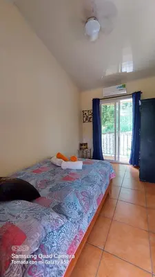 a bedroom with a bed and a large window at YETHAN HOUSE in Uvita