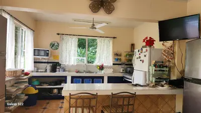 a kitchen with a refrigerator and a table with chairs at YETHAN HOUSE in Uvita