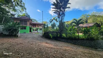 a house with a green facade and a yard at YETHAN HOUSE in Uvita