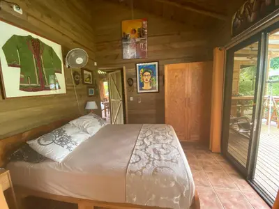 a bedroom with a bed in a wooden room at Uvita Oasis Retreat with Villa Apt Bungalows Cabin in Uvita
