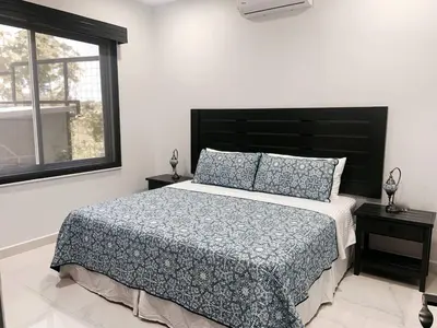 a bedroom with a bed with a black headboard and a window at Casamar Villa's in Uvita