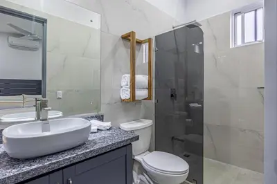 a bathroom with a sink and a toilet and a shower at Casamar Villa's in Uvita