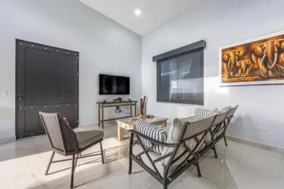 a living room with chairs and a table and a painting at Casamar Villa's in Uvita