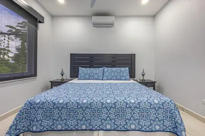 a bedroom with a bed with a blue comforter at Casamar Villa's in Uvita