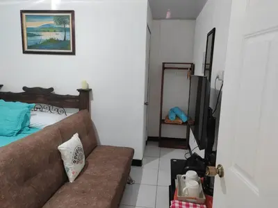 a living room with a couch and a television at Gran Hotel Desamparados in Desamparados