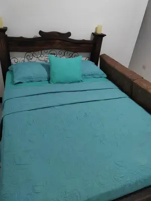 a bed with blue sheets and blue pillows at Gran Hotel Desamparados in Desamparados