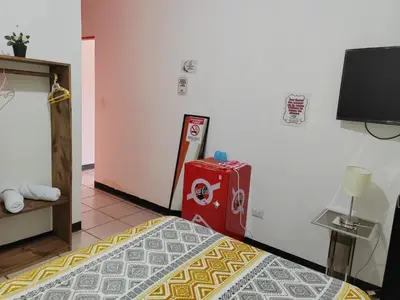 a room with a bed and a red refrigerator at Gran Hotel Desamparados in Desamparados