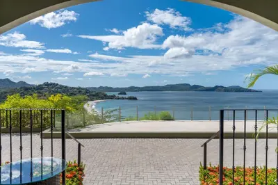 a view of the water from a balcony at Luxury Condo with Panoramic Ocean Views, Sparkling Infinity Pool, and Modern Open-Concept Design in Playa Flamingo