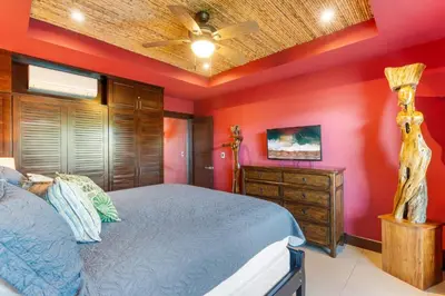 a bedroom with a bed and a ceiling fan at Luxury Condo with Panoramic Ocean Views, Sparkling Infinity Pool, and Modern Open-Concept Design in Playa Flamingo