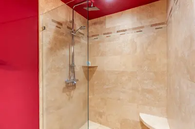 a bathroom with a shower with a glass door at Luxury Condo with Panoramic Ocean Views, Sparkling Infinity Pool, and Modern Open-Concept Design in Playa Flamingo