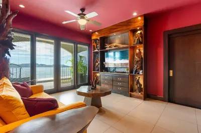 a living room with a couch and a tv at Luxury Condo with Panoramic Ocean Views, Sparkling Infinity Pool, and Modern Open-Concept Design in Playa Flamingo