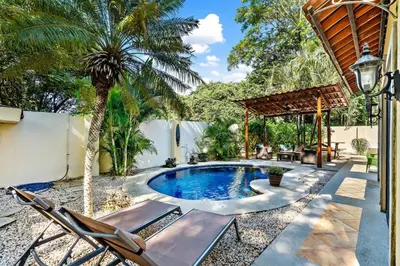 a backyard with a swimming pool and a palm tree at Inviting Home with Colorful Decor and Private Backyard Oasis with a Swimming Pool & Shaded Terrace in Santa Cruz