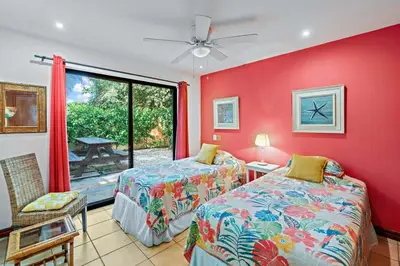two beds in a room with red walls and a window at Inviting Home with Colorful Decor and Private Backyard Oasis with a Swimming Pool & Shaded Terrace in Santa Cruz