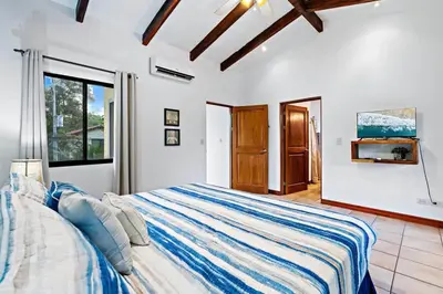 a bedroom with a large bed with blue and white sheets at Inviting Home with Colorful Decor and Private Backyard Oasis with a Swimming Pool & Shaded Terrace in Santa Cruz