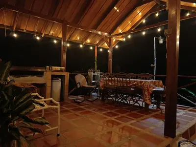 a patio with a table and chairs and lights at YETHAN HOUSE in Uvita