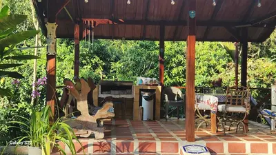 a pavilion with a table and chairs on a patio at YETHAN HOUSE in Uvita