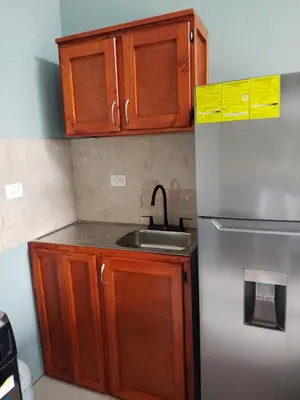 a kitchen with wooden cabinets and a stainless steel refrigerator at Depa Soto in San Isidro