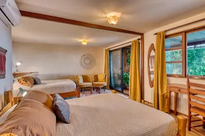 a bedroom with two beds and a living room at Hotel Amor de Mar in Montezuma