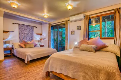 a bedroom with two beds and a window at Hotel Amor de Mar in Montezuma