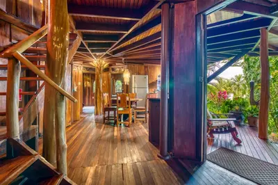 a home with a wooden floor and a dining room at Hotel Amor de Mar in Montezuma