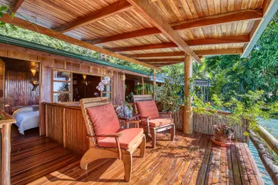 a porch with two chairs on a wooden deck at Hotel Amor de Mar in Montezuma