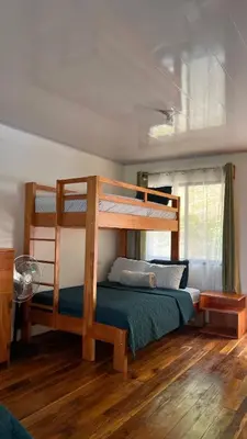 a bedroom with a bunk bed and wooden floors at Bungalows Paraíso Celeste in Bijagua
