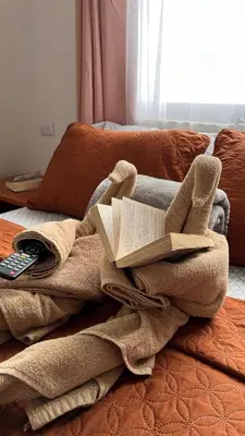 a blanket with an open book on top of a bed at Bungalows Paraíso Celeste in Bijagua