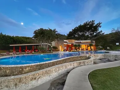 a large swimming pool with a resort in the background at CR MARIPOSA RENTALS Comfortable penthouse, AC, pool, gym, tennis in Santa Ana