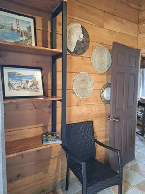 a black chair in a room with a wooden wall at Preciosa cabaña en Fraijanes in Fraijanes