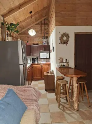 a kitchen with a table and a stainless steel refrigerator at Preciosa cabaña en Fraijanes in Fraijanes