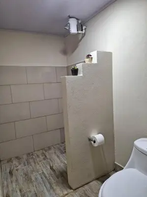 a bathroom with a toilet and a toilet paper dispenser at Preciosa cabaña en Fraijanes in Fraijanes