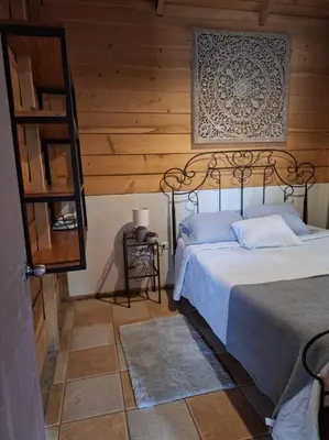 a bedroom with a bed and a wooden wall at Preciosa cabaña en Fraijanes in Fraijanes