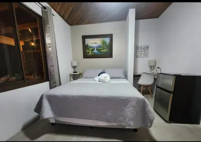 a bedroom with a bed with a towel on it at Airport Green Studio in Santiago Este