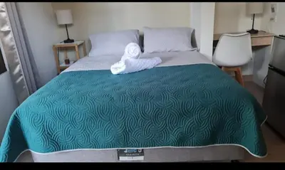 a bedroom with a bed with two towels on it at Airport Green Studio in Santiago Este