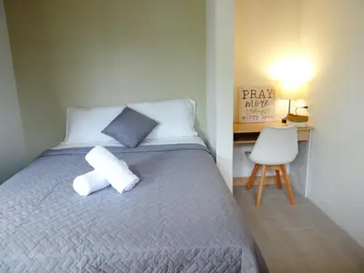 a bedroom with a bed with a pillow and a chair at Airport Green Studio in Santiago Este