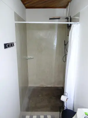 a shower with a glass door in a bathroom at Airport Green Studio in Santiago Este