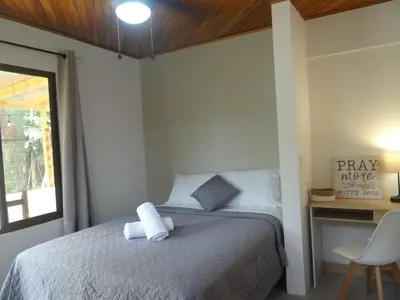 a bedroom with a bed and a table and a chair at Airport Green Studio in Santiago Este