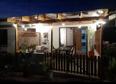 a fence in front of a house at night at Airport Green Studio in Santiago Este