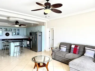 a living room with a couch and a ceiling fan at Seaside Serenity 2b2b with Panoramic Terrace in Coco