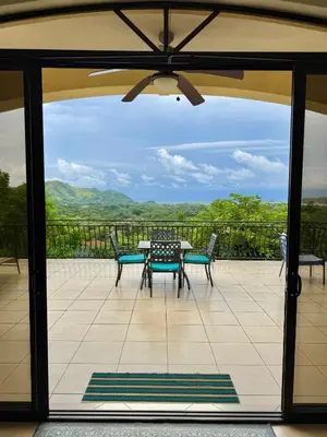 a patio with a table and chairs on a balcony at Seaside Serenity 2b2b with Panoramic Terrace in Coco