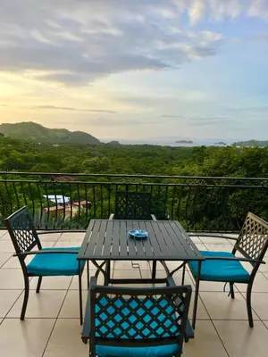 a table and chairs on a balcony with a view at Seaside Serenity 2b2b with Panoramic Terrace in Coco