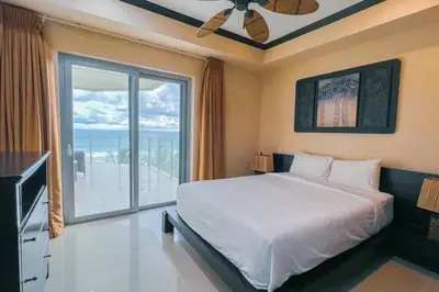 a bedroom with a large bed and a large window at Luxury beach condo, stunning sunset & ocean view in Jacó
