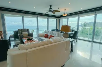 a living room with a couch and a table and chairs at Luxury beach condo, stunning sunset & ocean view in Jacó