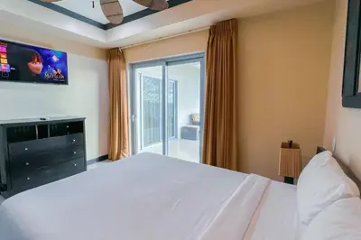 a bedroom with a large white bed and a window at Luxury beach condo, stunning sunset & ocean view in Jacó