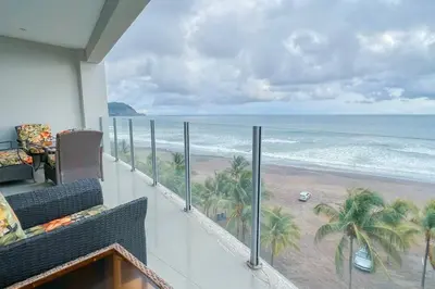 a balcony with a view of the beach at Luxury beach condo, stunning sunset & ocean view in Jacó