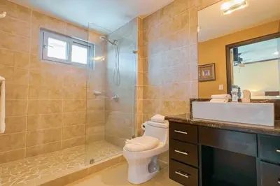 a bathroom with a toilet and a shower and a sink at Luxury beach condo, stunning sunset & ocean view in Jacó
